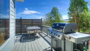 A deck with a grill, a table, and chairs. - Yellowstone Country Home - Launchpad for a trip of a lifetime!  (Livingston)