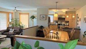 A modern kitchen with wooden cabinets, a central island, and pendant lighting. - Yellowstone Country Home - Launchpad for a trip of a lifetime!  (Livingston)