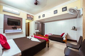 A hotel room with two beds, a TV, a fan, and motivational wall art. - Malar Residencey (Puducherry)