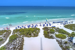 A beach with numerous umbrellas and a clear view of the ocean.