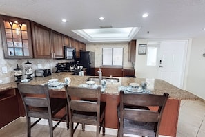 A kitchen with a central island, wooden cabinets, and a skylight.