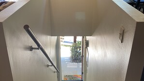 Un escalier menant à un niveau inférieur, d’où l’on a vue sur la rue.