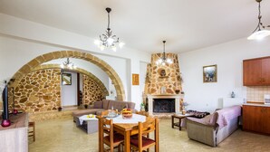 Ein gemütlicher Wohnbereich mit Kamin, einem Esstisch mit Stühlen und einer Couch.
