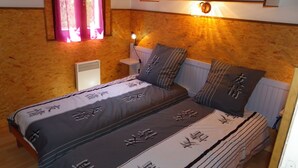 A bedroom with a bed, pillows, a nightstand, a wall-mounted light, and a window with curtains. - LES BALCONS DE LA CHIUSA House 6 persons 3 bedrooms in VICO 13 km from the beach (VICO)