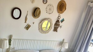 Una cama bien tendida con ropa de cama blanca, un cabecero con un panel decorativo y una mesita de noche con una lámpara.