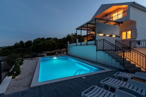 A modern house with a swimming pool, outdoor seating, and a staircase leading to a balcony. - Vacation House Miramar (Seget)