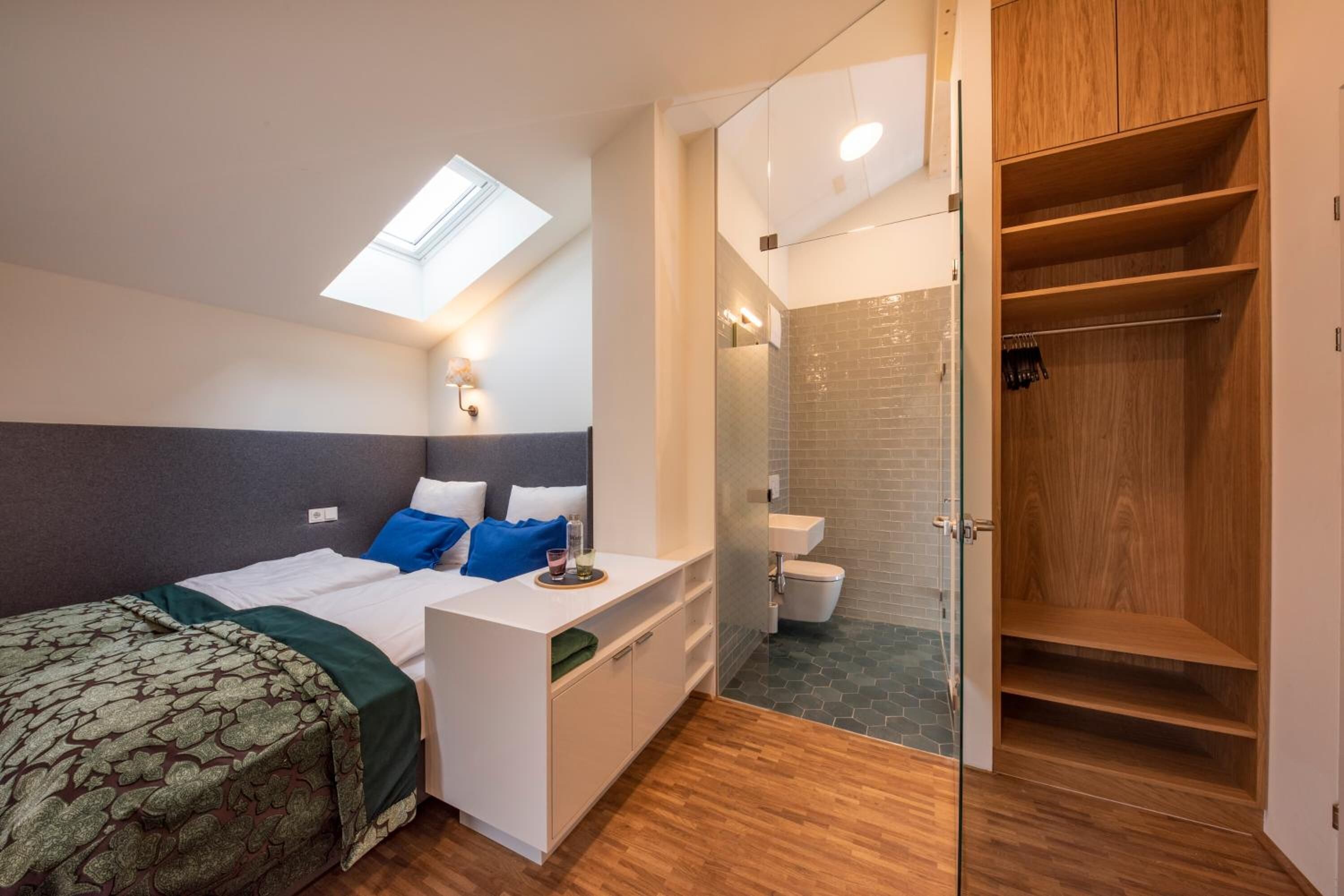 Une chambre à coucher avec un lit, une table de chevet et une lucarne.