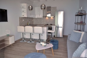 A modern kitchen with a central island, bar stools, and a built-in oven. - Villa Philippos on Dechoumenes Beach - Agios Gordios, Corfu (Corfu)