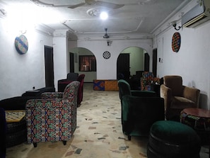 Una habitación con sofás estampados, un dardo y un tablero de ajedrez.