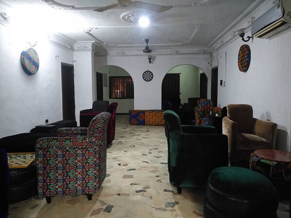 Una habitación con sofás estampados, un dardo y un tablero de ajedrez.