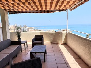 Enjoy the ocean view from this balcony with a seating area featuring a sofa, chairs, and table.