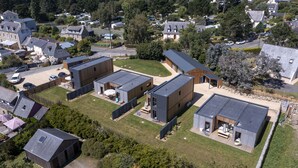 Un barrio residencial con casas modernas, un patio cubierto de césped y vista al mar.