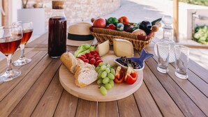 Ein Holztisch mit einer Wurstplatte, Weingläsern und einer Weinflasche.