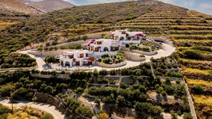 Eine weiße Villa mit mehreren Zimmern, umgeben von Olivenhainen und einem Bergpanorama.