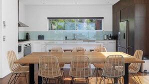 Una cucina moderna con isola centrale, mobili bianchi e un'ampia finestra.