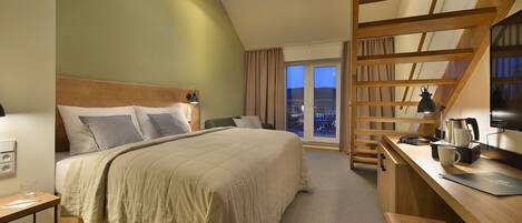 Une chambre d’hôtel avec un lit, un bureau et une vue sur l’extérieur.