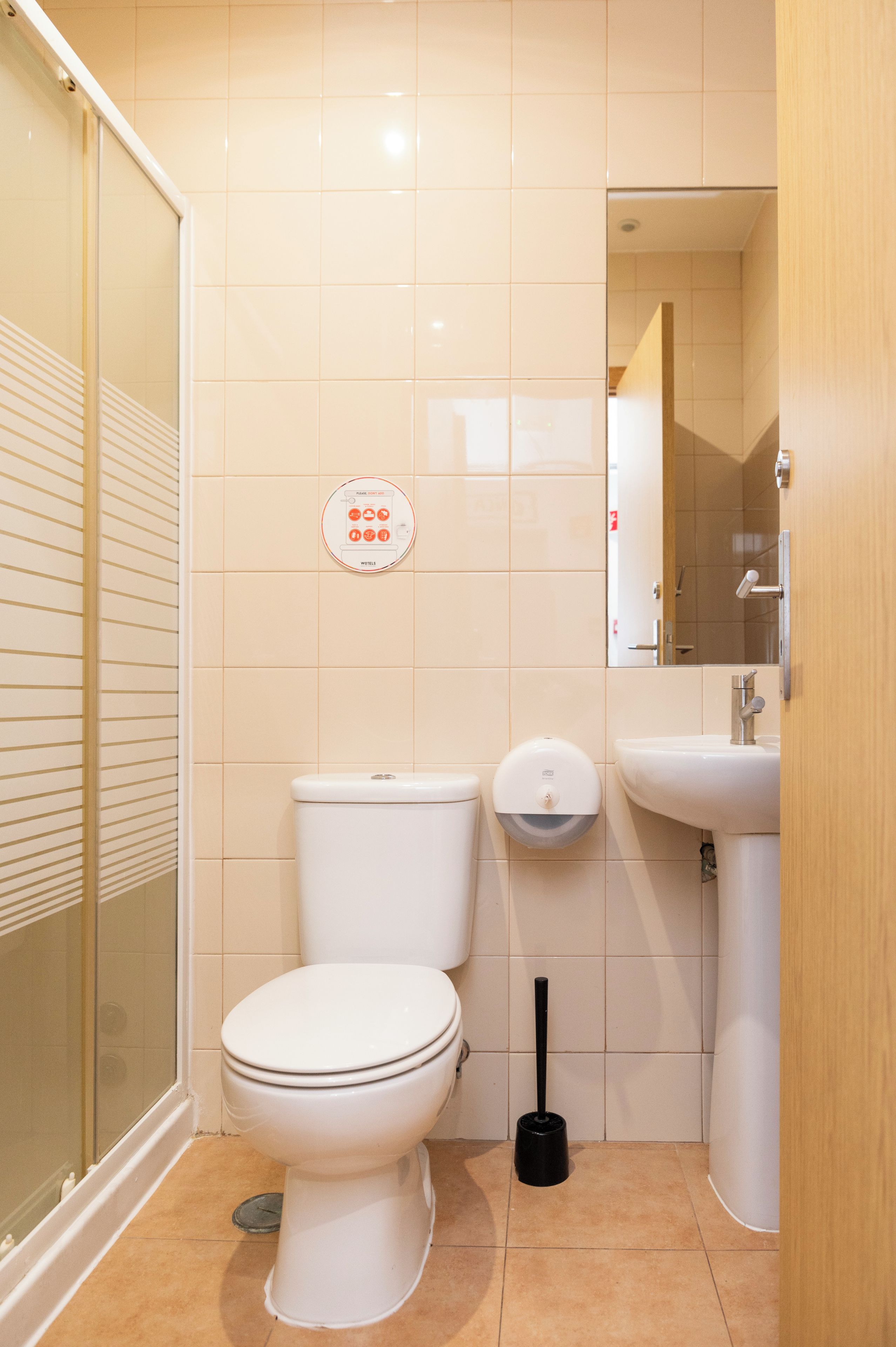 A bathroom with a toilet, a bidet, a sink, and a mirror.