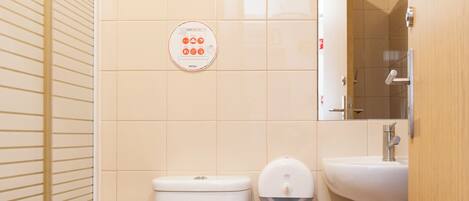 A bathroom with a toilet, a bidet, a sink, and a mirror.