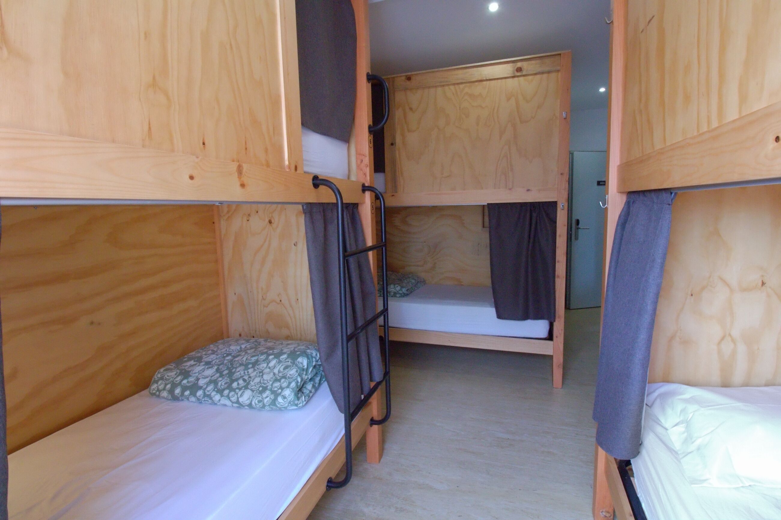 A bunk bed room with wooden walls and a simple layout.