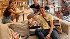 Un interior moderno con ventanas amplias, mesas de madera y zonas de estar cómodas.