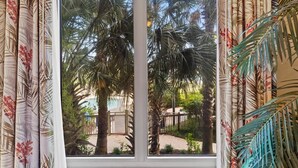 A window with a view of palm trees and a paved area outside. - One-of-a-Kind 4 Bed / 4 Bath Oceanfront Retreat | ML03 (Myrtle Beach)