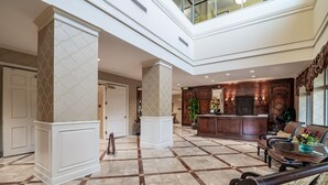 A spacious lobby with a high ceiling, a reception desk, comfortable seating, and a decorative plant. - One-of-a-Kind 4 Bed / 4 Bath Oceanfront Retreat | ML03 (Myrtle Beach)