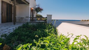 Un edificio moderno e bianco con una veranda coperta e vista sul mare.