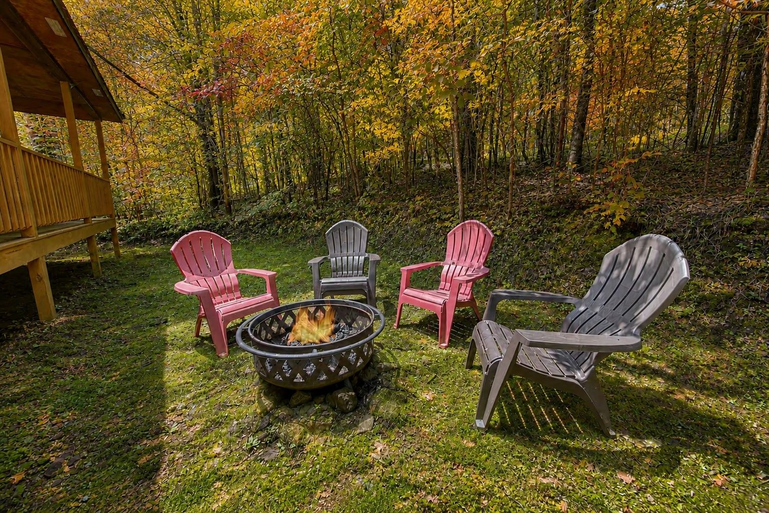 Un espace extérieur aménagé avec des chaises Adirondack et un foyer.
