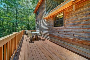 Eine Holzhütte mit einer Veranda und einem Tisch mit Stühlen.