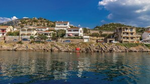A coastal town with buildings along the waterfront, featuring balconies, stone walls, and a clear view of the sea. - Amazing Home in Sveti Juraj With Wifi and 0 Bedrooms (Senj)