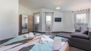 A modern bedroom with a bed, a sofa, a TV, and a large window. - Beautiful Home in Pula With Wifi and 7 Bedrooms (Pula)