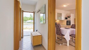 A hallway leading to a dining area with a table and chairs, a wooden bench, and a view of the outside. - Nice Home in Zminj with Hot Tub, WiFi & 1 Bedrooms (Zminj)