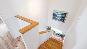 Eine Holztreppe mit einer weißen Wand und einem gerahmten Bild darüber.