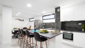 A modern kitchen with a central island, bar stools, a refrigerator, a stove, and a sink. - Stunning Home in Razanj With 10 Bedrooms, Wifi and Heated Swimming Pool (Rogoznica)
