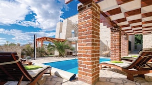 A poolside area with lounge chairs, a brick pillar, and a pergola. - Awesome Home in Novigrad With 4 Bedrooms, Sauna and Wifi (Novigrad)