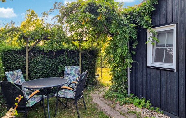 Relax in this serene, plant-filled courtyard with a round table and chairs.