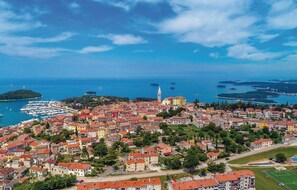 An aerial view of a coastal town with a prominent tower, marina, and surrounding islands. - Awesome Home in Vrsar With Wifi and 0 Bedrooms (Vrsar)