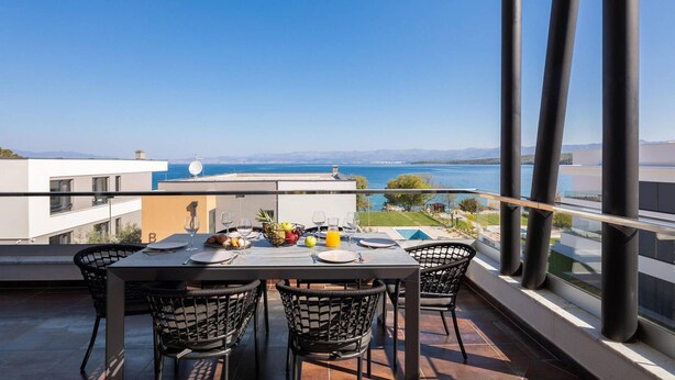 A dining area with a table set for four, overlooking a body of water and distant hills. - Amazing Home in Zidarici With Outdoor Swimming Pool, Wifi and 6 Bedrooms (Malinska-Dubasnica)
