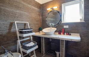 A bathroom with a white vanity, a round mirror, a sink, and a small potted plant. - Amazing Home in Linardici With Wifi and 6 Bedrooms (Krk)