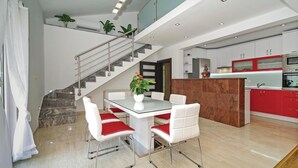 A modern kitchen with red cabinets, a marble island, and stainless steel appliances. - Awesome Home in Umcani With Wifi and 9 Bedrooms (Vrgorac)