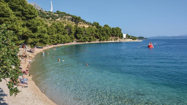 A coastal beach with clear waters, a lighthouse, and a red buoy in the distance. - Awesome Home in Umcani With Wifi and 9 Bedrooms (Vrgorac)