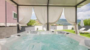 A hot tub with a view of a green lawn and mountains in the background. - Awesome Home in Umcani With Wifi and 9 Bedrooms (Vrgorac)