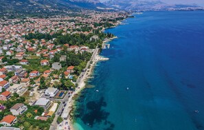 An aerial view of a coastal town with residential buildings, a beach, and a clear blue sea. - Nice Apartment in Kastel Stari With Wifi (Kastela)