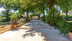 A paved pathway leading to a gated entrance, surrounded by lush greenery and trees. - Beautiful Home in Svetvincenat With Wifi and 1 Bedrooms (Svetvincenat)