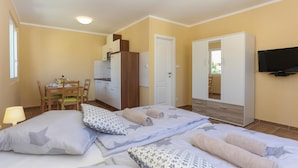 A bedroom with two beds, a desk, a wardrobe, and a TV. - Awesome Apartment in Kastel Stari With Wifi (Kastela)