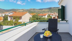 A balcony with a table set for two, featuring a plate of fruit and a glass of milk. - Awesome Apartment in Kastel Stari With Wifi (Kastela)