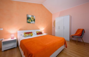 A bedroom with a bed, a nightstand, a chair, a wardrobe, and a painting on the wall. - Nice Home in Kmacici With Outdoor Swimming Pool, Wifi and 3 Bedrooms (Tinjan)