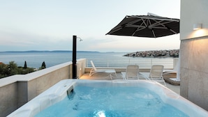 Ein Whirlpool mit Meerblick, Sitzgelegenheiten im Freien und eine Pergola.