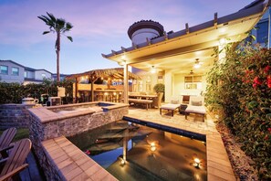 Un patio con piscina, mobiliario exterior y una zona de comedor cubierta.