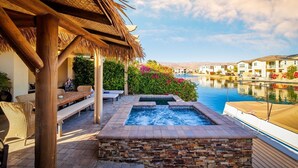 A pool area with a hot tub, lounge chairs, and a view of a residential neighborhood. - 🏝️Chic villa on the lake! 3 bed 3 bath, Golf, bbq & fun in the sun 🌵🏝️🍦👙 (Indio)